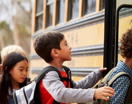 School children in line to get on a school bus