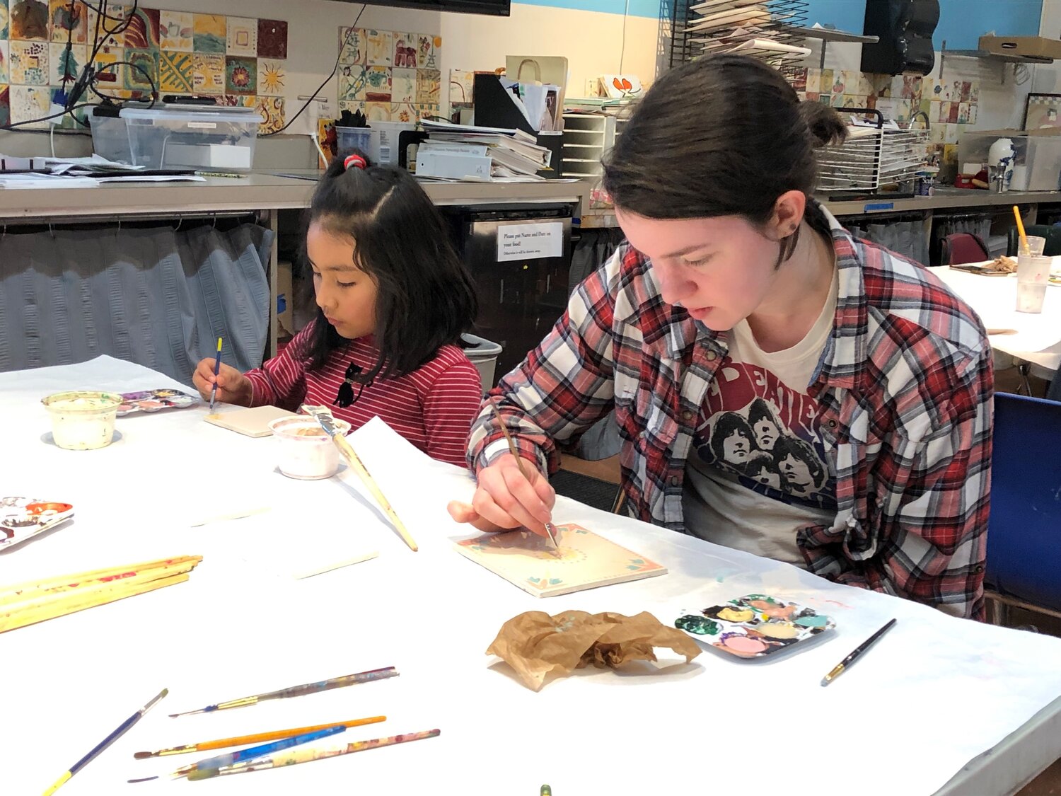 Teenager and child working on art project